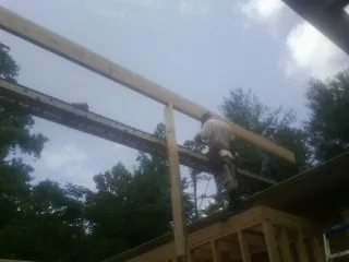 Carpenter setting a ridge beam over a new addition frame — Ice Dam Removal by Roofing Brothers in Stone Park