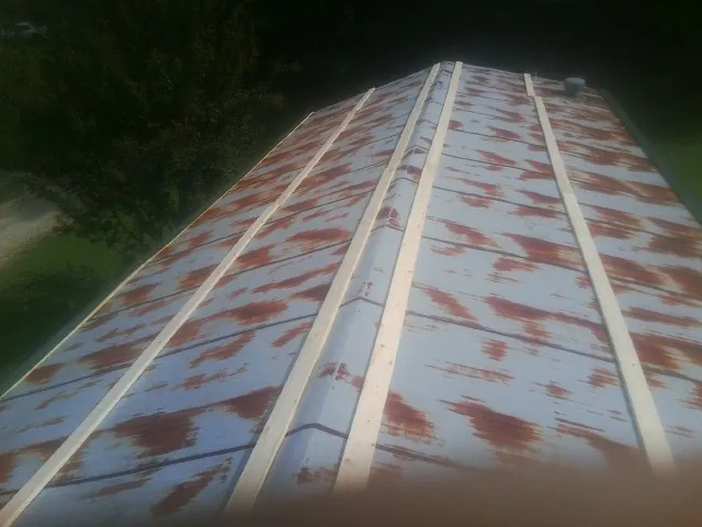 Rusted metal roof panels with new wood purlins before replacement — Storm Damage Roof Repair in Stone Park by Roofing Brothers