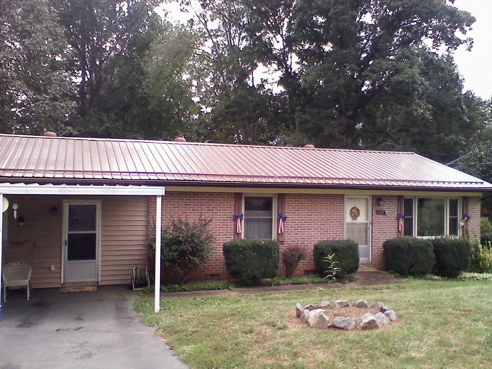 Bronze metal roof and carport on a brick ranch home — Roof Repair work by our crew in Stone Park